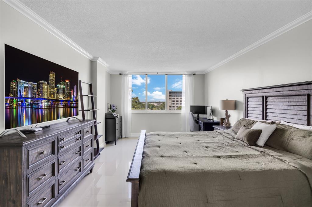 4200 Hillcrest Drive, Unit 711 Hollywood, FL 33021 - Photo 14 of 37 a bed room with bed and a book shelf