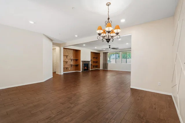 a view of a room with wooden floor and chandelier