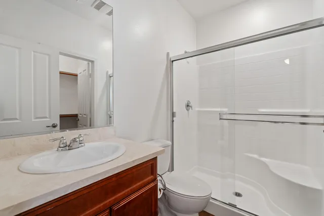 a bathroom with a granite countertop sink toilet and shower