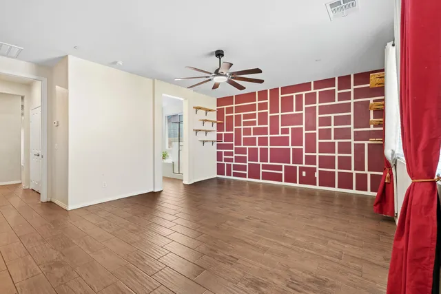 a view of empty room with wooden floor and windows