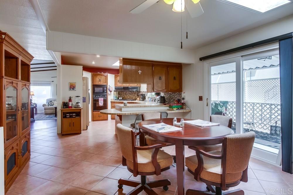 1175 La Moree Road, Unit 52 San Marcos, CA 92078 - Photo 14 of 54 a dining room with stainless steel appliances kitchen island granite countertop a table chairs and a living room view