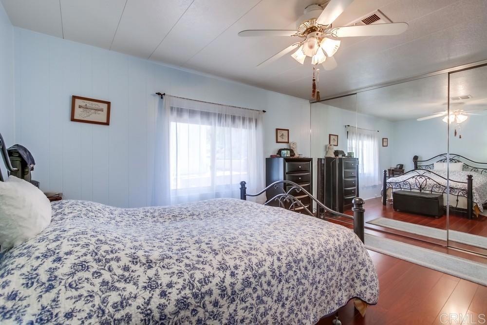 1175 La Moree Road, Unit 52 San Marcos, CA 92078 - Photo 16 of 54 a bedroom that has a bed and a chandelier