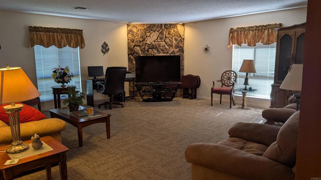 1175 La Moree Road, Unit 52 San Marcos, CA 92078 - Photo 44 of 54 a living room with furniture a flat screen tv and a window