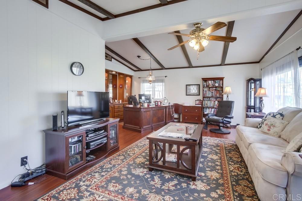 1175 La Moree Road, Unit 52 San Marcos, CA 92078 - Photo 6 of 54 a living room with furniture a flat screen tv and kitchen view