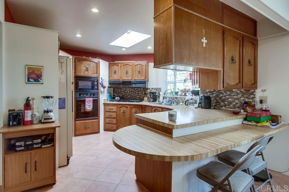 1175 La Moree Road, Unit 52 San Marcos, CA 92078 - Photo 10 of 54 a kitchen with stainless steel appliances granite countertop a sink and a refrigerator