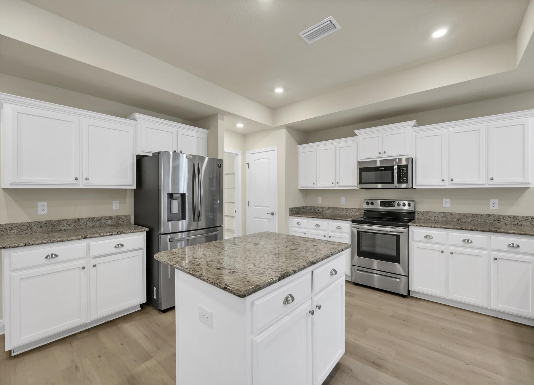 3639 Ranch Drive Crestview, FL 32539 - Photo 24 of 84 a kitchen with stainless steel appliances granite countertop a stove a sink dishwasher a refrigerator and white cabinets with wooden floor