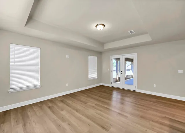 an empty room with window and ceiling fan