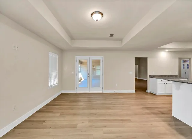 an empty room with windows and fan