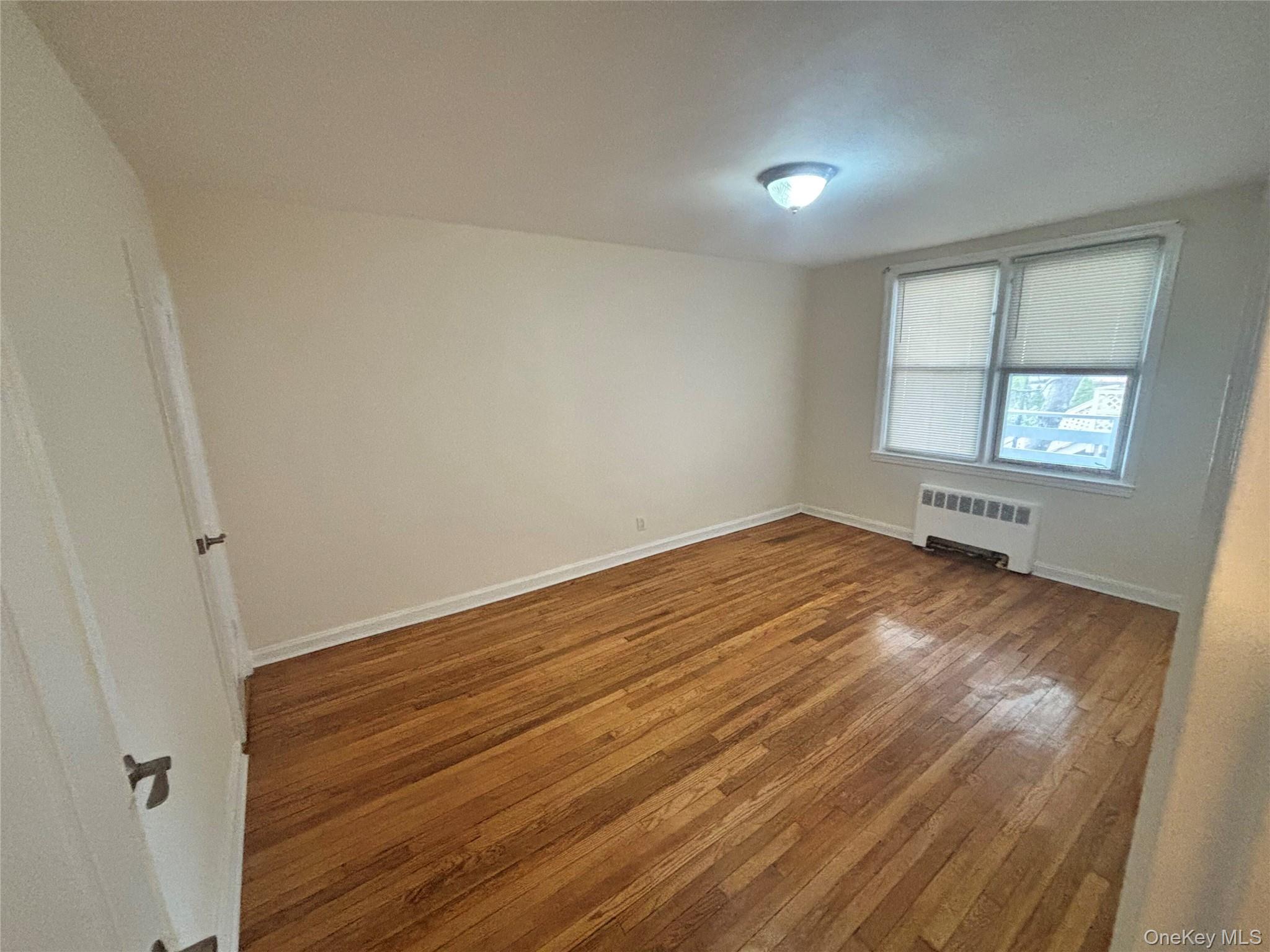 253-29 85th Road Queens, NY 11426 - Photo 1 of 8 a view of empty room with wooden floor and fan