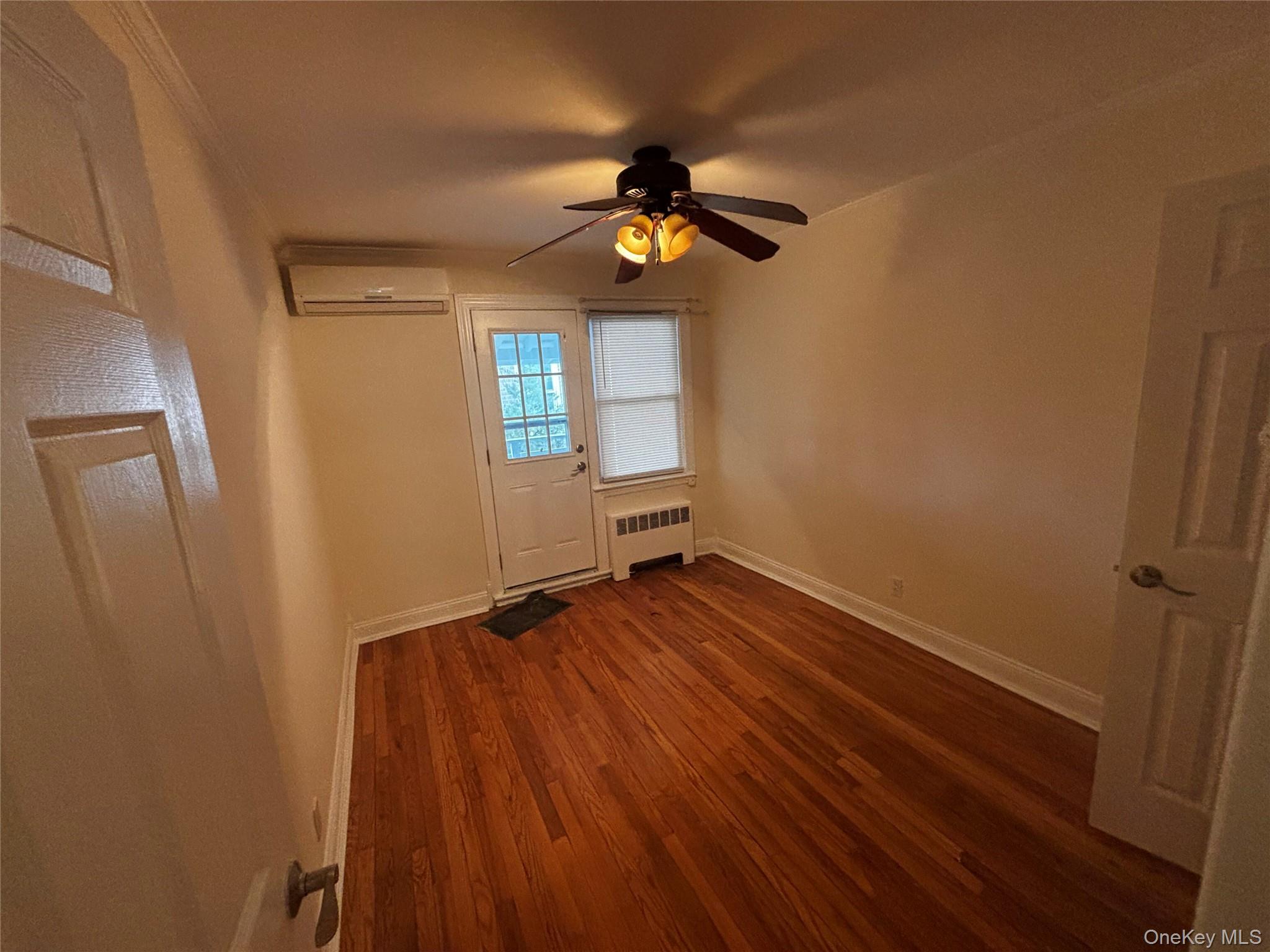 253-29 85th Road Queens, NY 11426 - Photo 6 of 8 wooden floor in an empty room with a window