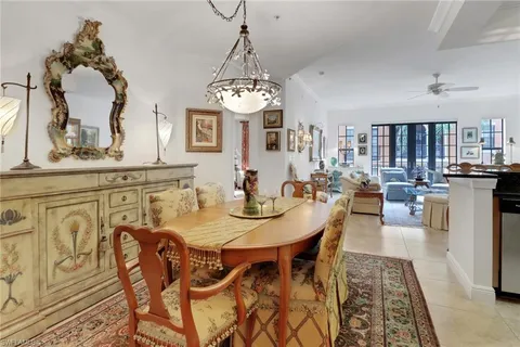 a kitchen with stainless steel appliances granite countertop a refrigerator a stove a sink a dining table and chairs with wooden floor