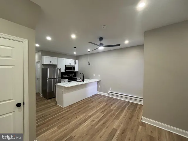 a kitchen with stainless steel appliances a refrigerator and a stove top oven