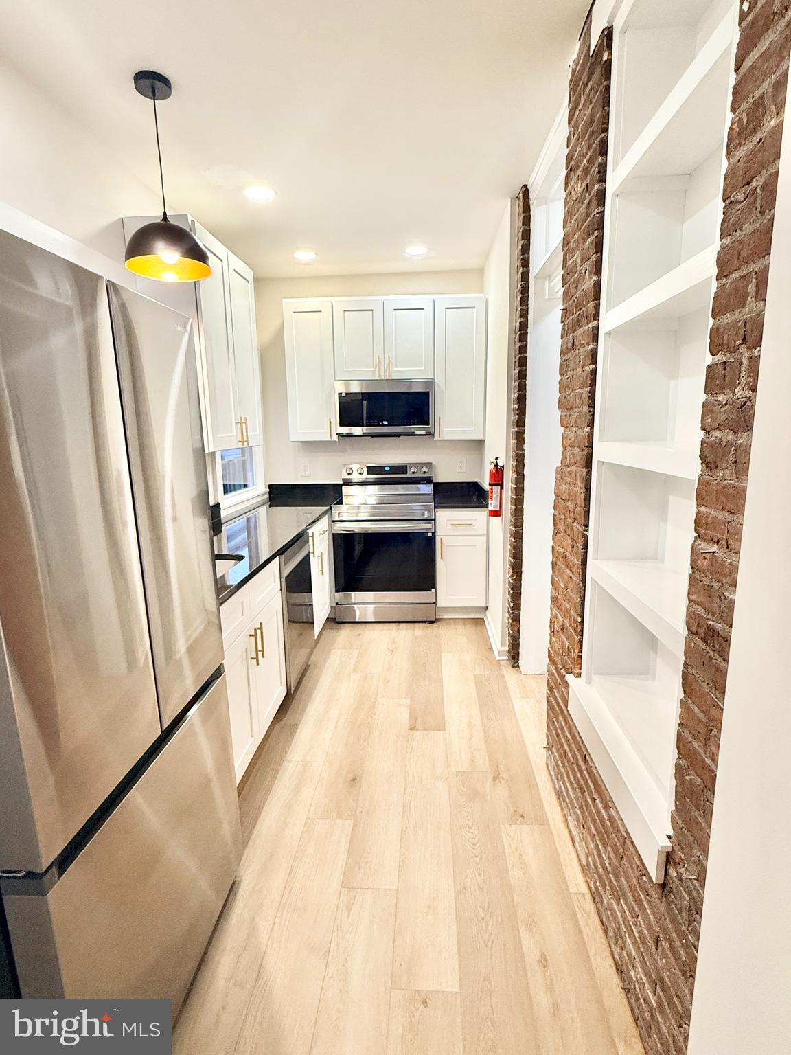 123 North Hanover Street, Unit 1 Pottstown, PA 19464 - Photo 6 of 22 a view of kitchen with stainless steel appliances wooden floor and window