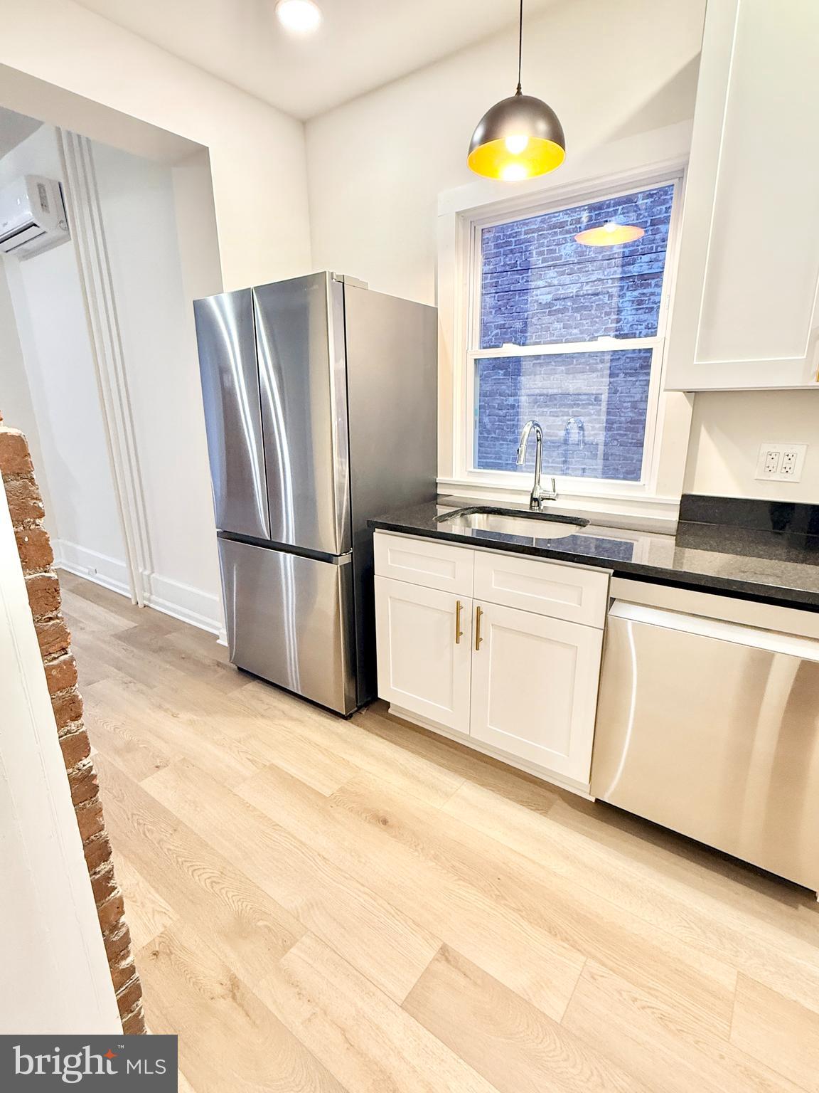 123 North Hanover Street, Unit 1 Pottstown, PA 19464 - Photo 8 of 22 a kitchen with stainless steel appliances granite countertop a refrigerator a stove a sink and dishwasher with wooden floor