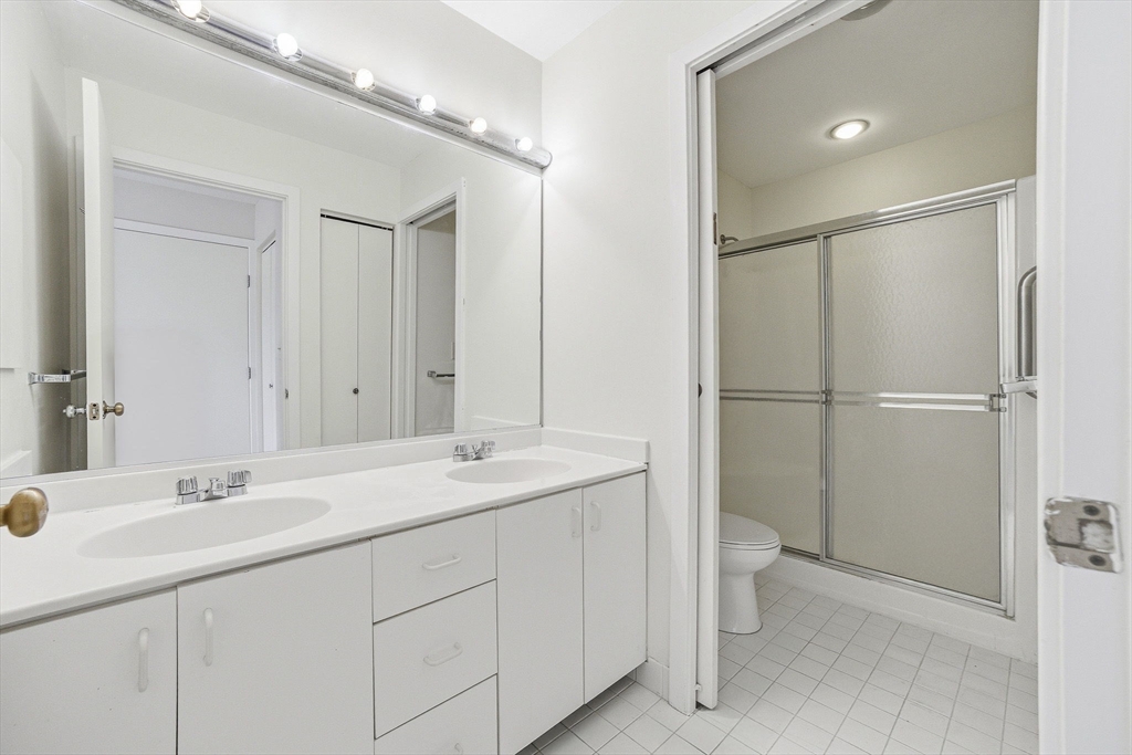 100 Rosemary Way, Unit 324 Needham, MA 02494 - Photo 13 of 27 a bathroom with a double vanity sink toilet and mirror