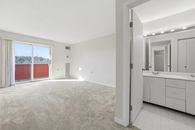 an empty room with wooden floor and glass door
