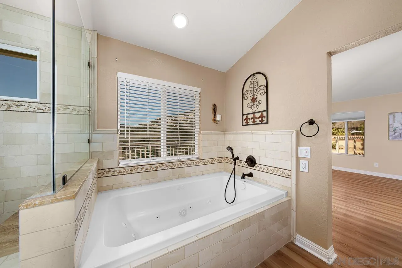 13558 Quiet Hills Drive Poway, CA 92064 - Photo 32 of 61 a bathroom with a tub sink and mirror