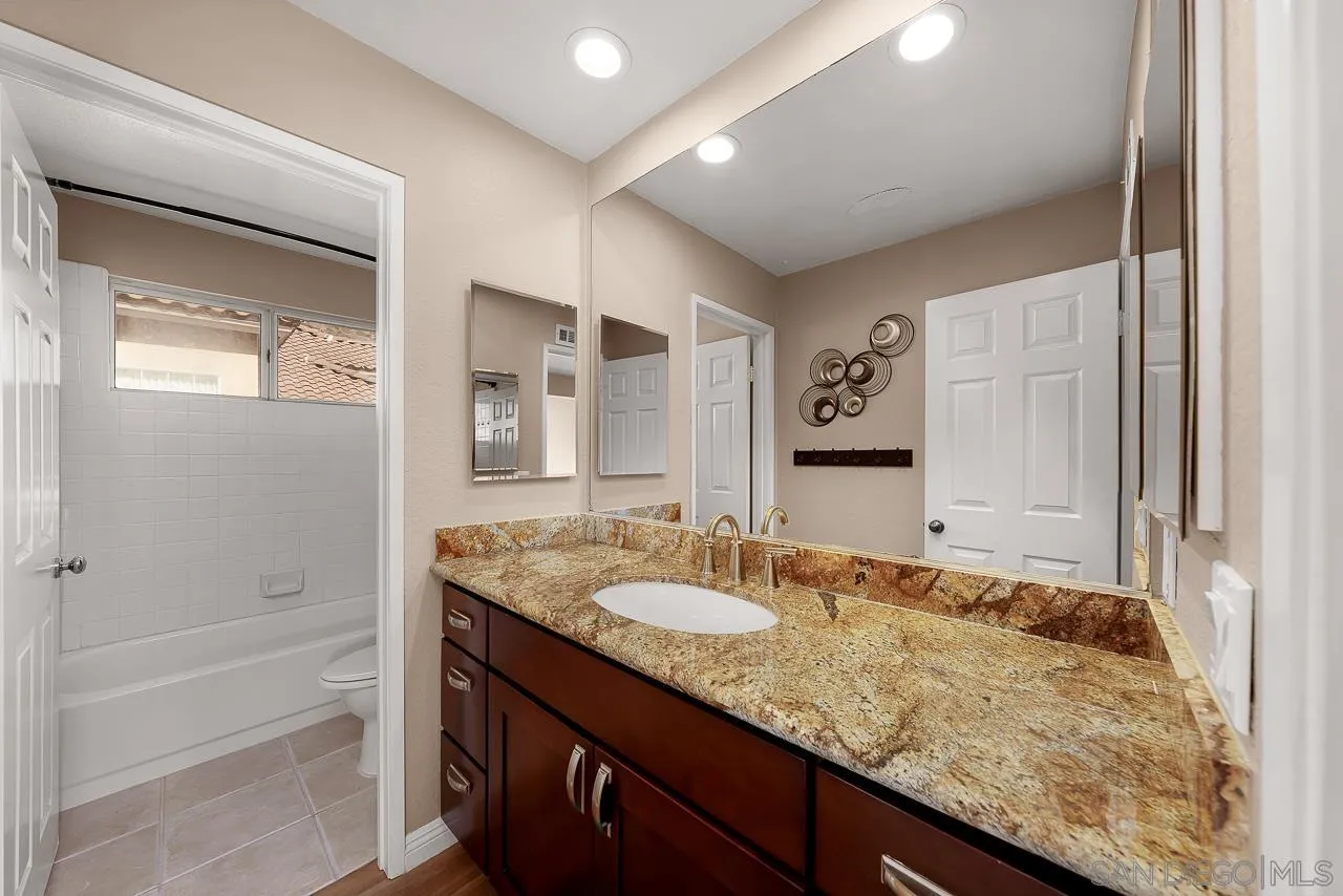13558 Quiet Hills Drive Poway, CA 92064 - Photo 37 of 61 a bathroom with a granite countertop sink and a mirror