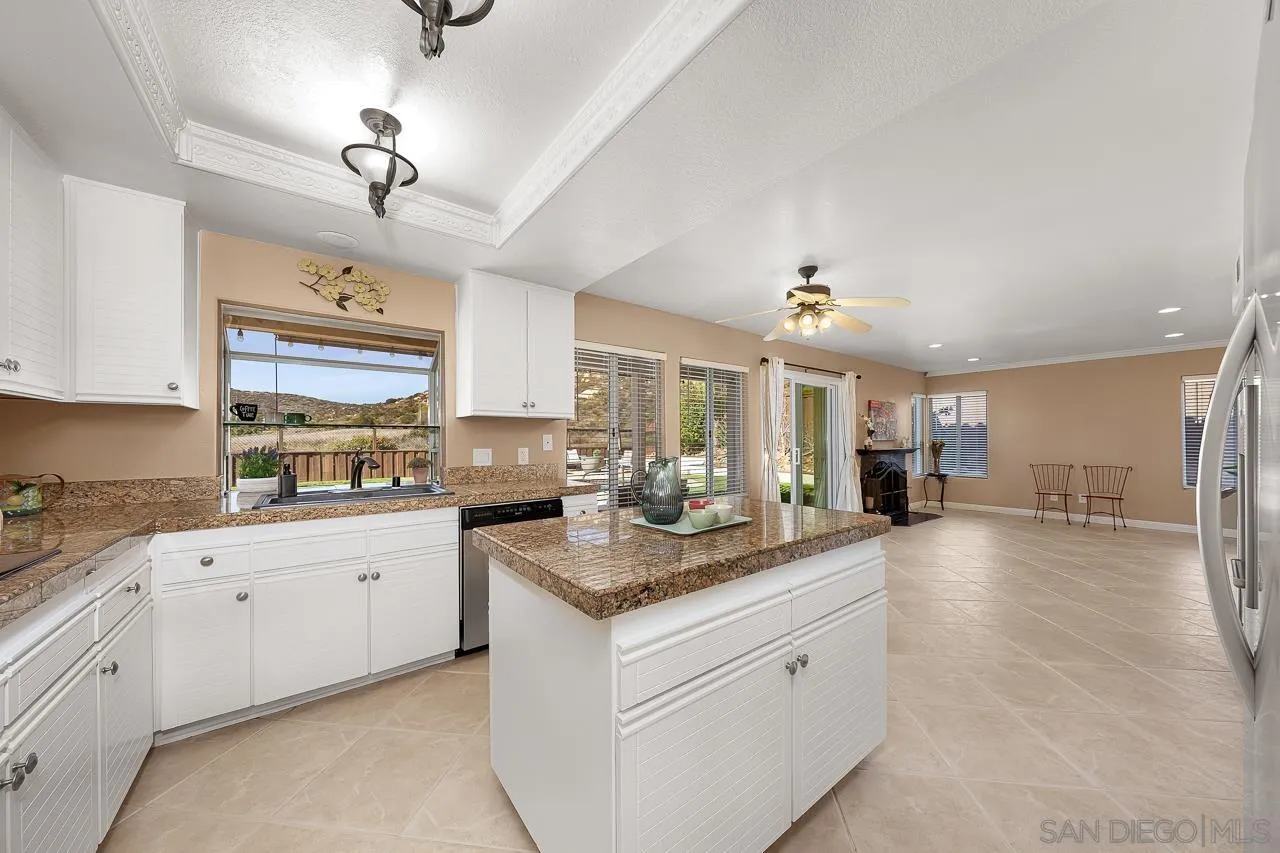 13558 Quiet Hills Drive Poway, CA 92064 - Photo 10 of 61 a large kitchen with kitchen island a large counter space a sink stainless steel appliances and cabinets