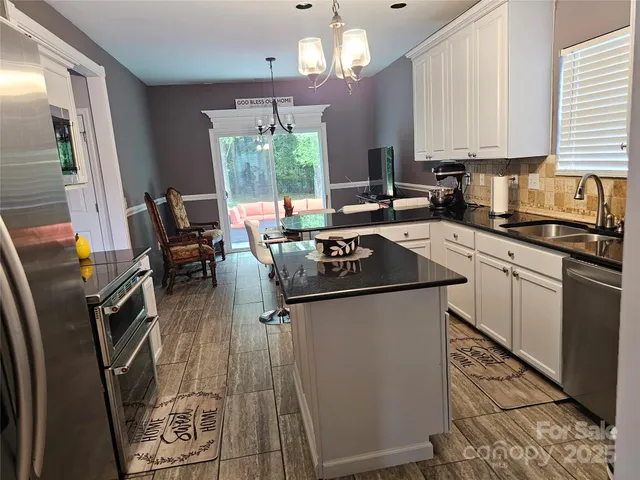 a kitchen with stainless steel appliances a stove a sink dishwasher and cabinets with wooden floor