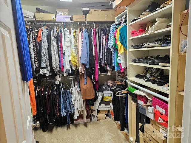 a view of walk in closet with clothes