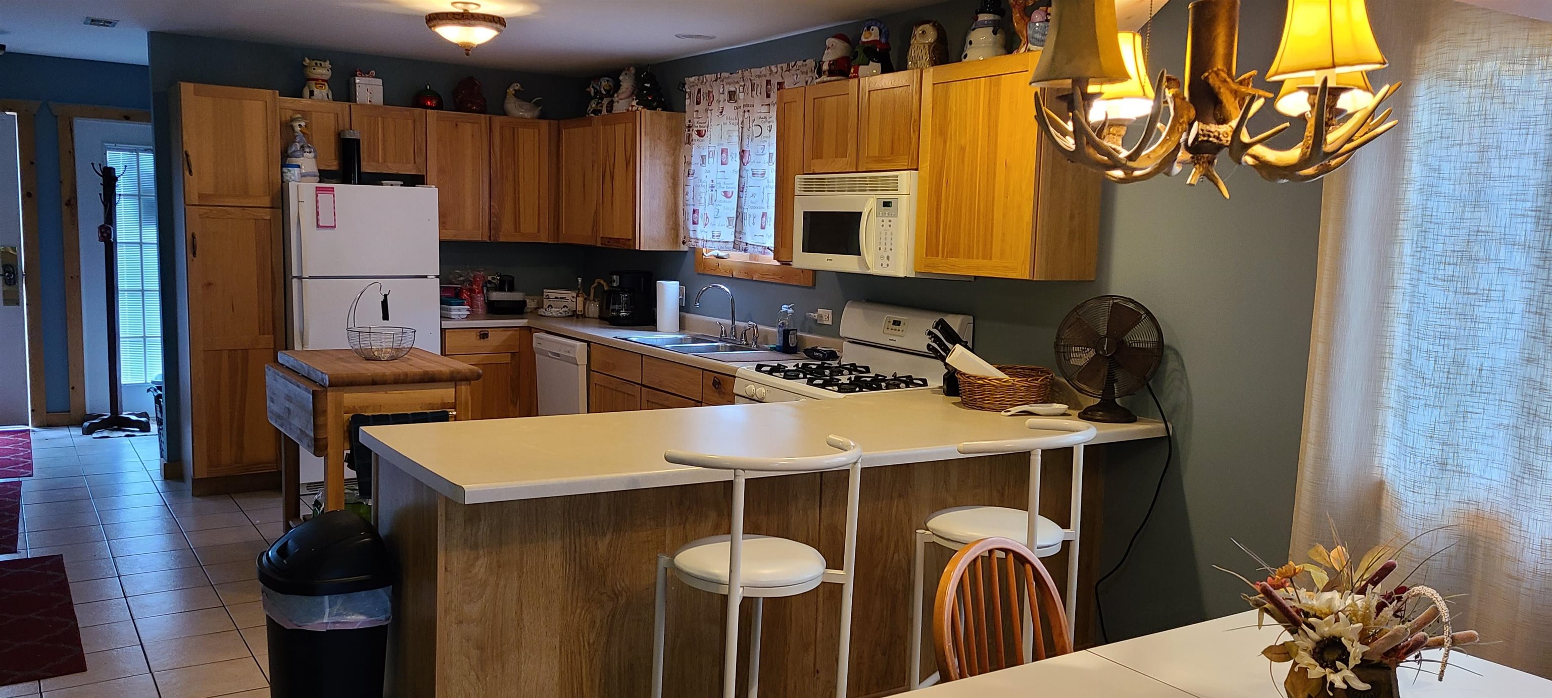 2643 Highway 178, Unit Q1 Utica, IL 61373 - Photo 14 of 21 a kitchen with stainless steel appliances a sink a refrigerator a stove a dining table and chairs with wooden floor