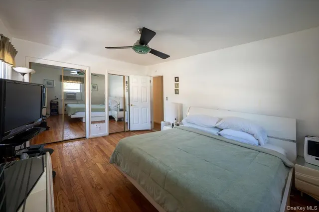 a spacious bedroom with a bed and a flat screen tv