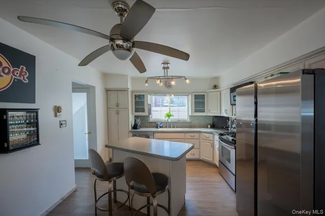 a kitchen with stainless steel appliances granite countertop a sink a stove and a refrigerator