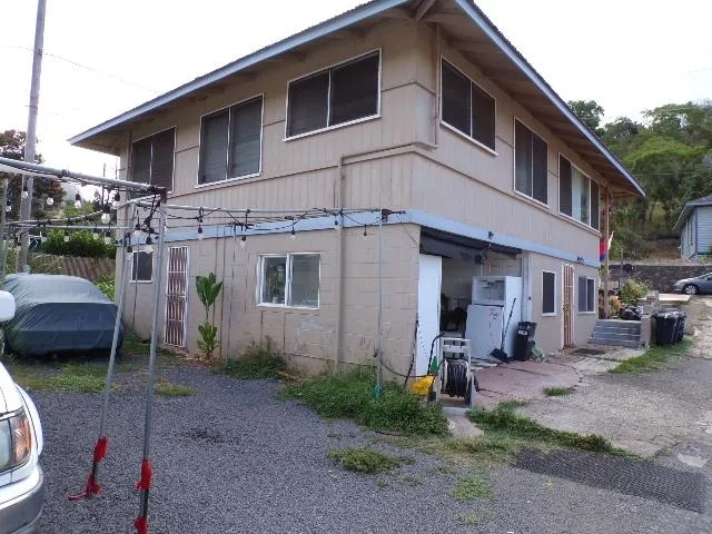 a view of a house with a yard and lawn chairs
