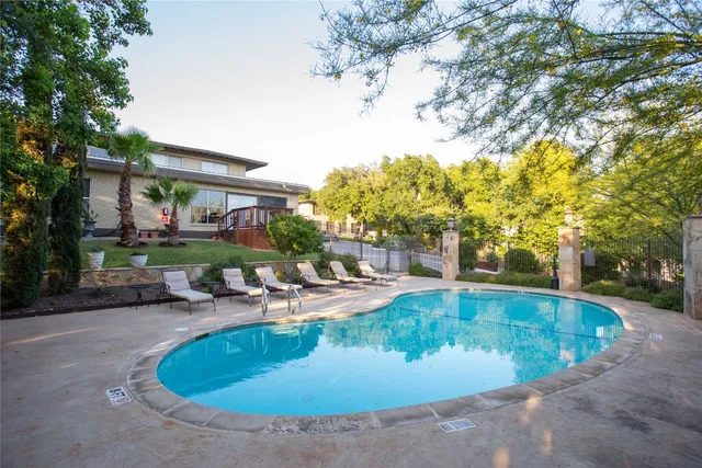 a view of a swimming pool with some plants and trees