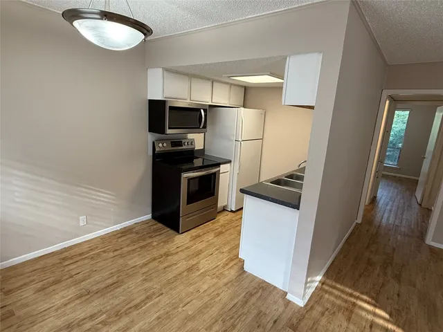 a kitchen with stainless steel appliances granite countertop a refrigerator a stove a sink and dishwasher