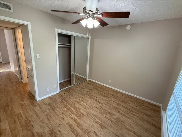 a view of room with hardwood floor and ceiling fan
