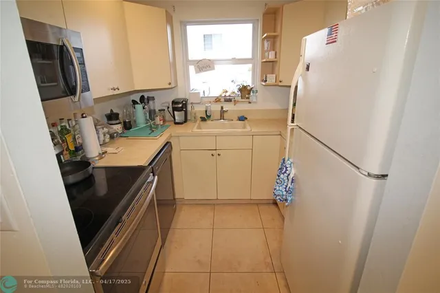 a kitchen with stainless steel appliances a refrigerator sink and microwave
