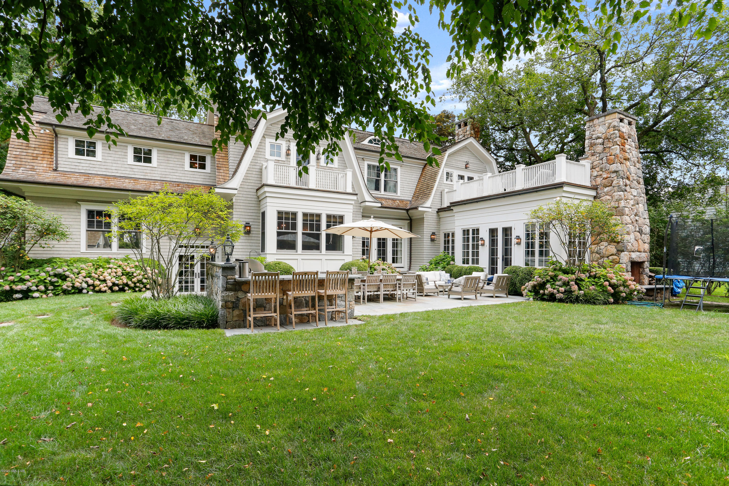 47 Shore Road Old Greenwich, CT 06870 - Photo 1 of 4 a front view of a house with a garden and trees