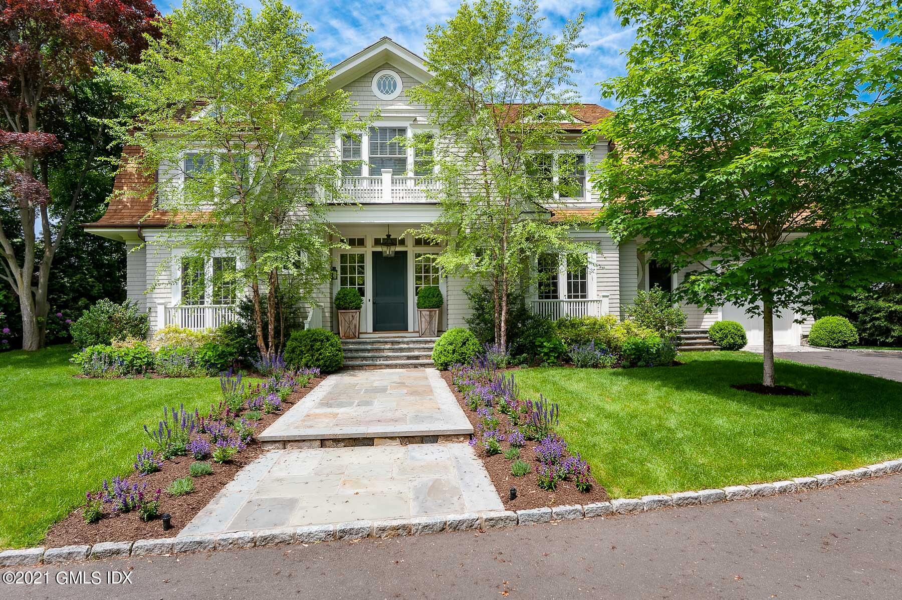 47 Shore Road Old Greenwich, CT 06870 - Photo 2 of 4 a front view of a house with a garden
