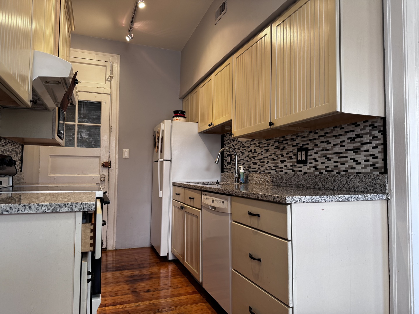 6249 North Sheridan Road, Unit 5 Chicago, IL 60660 - Photo 5 of 32 a kitchen with granite countertop a stove and a refrigerator