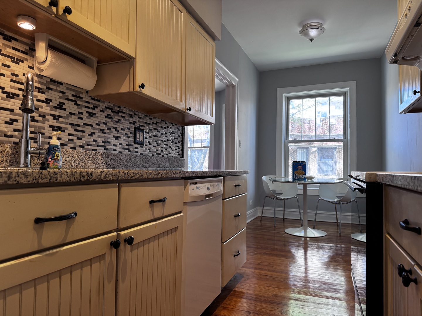 6249 North Sheridan Road, Unit 5 Chicago, IL 60660 - Photo 8 of 32 a kitchen with sink cabinets and wooden floor