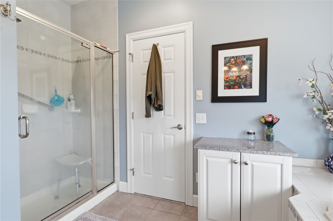 4536 Crystal Ridge Circle Gorham, NY 14424 - Photo 22 of 48 Primary bathroom features a convenient low-step entry shower for easy access, as well as luxurious heated flooring throughout to ensure maximum warmth and comfort during all seasons.