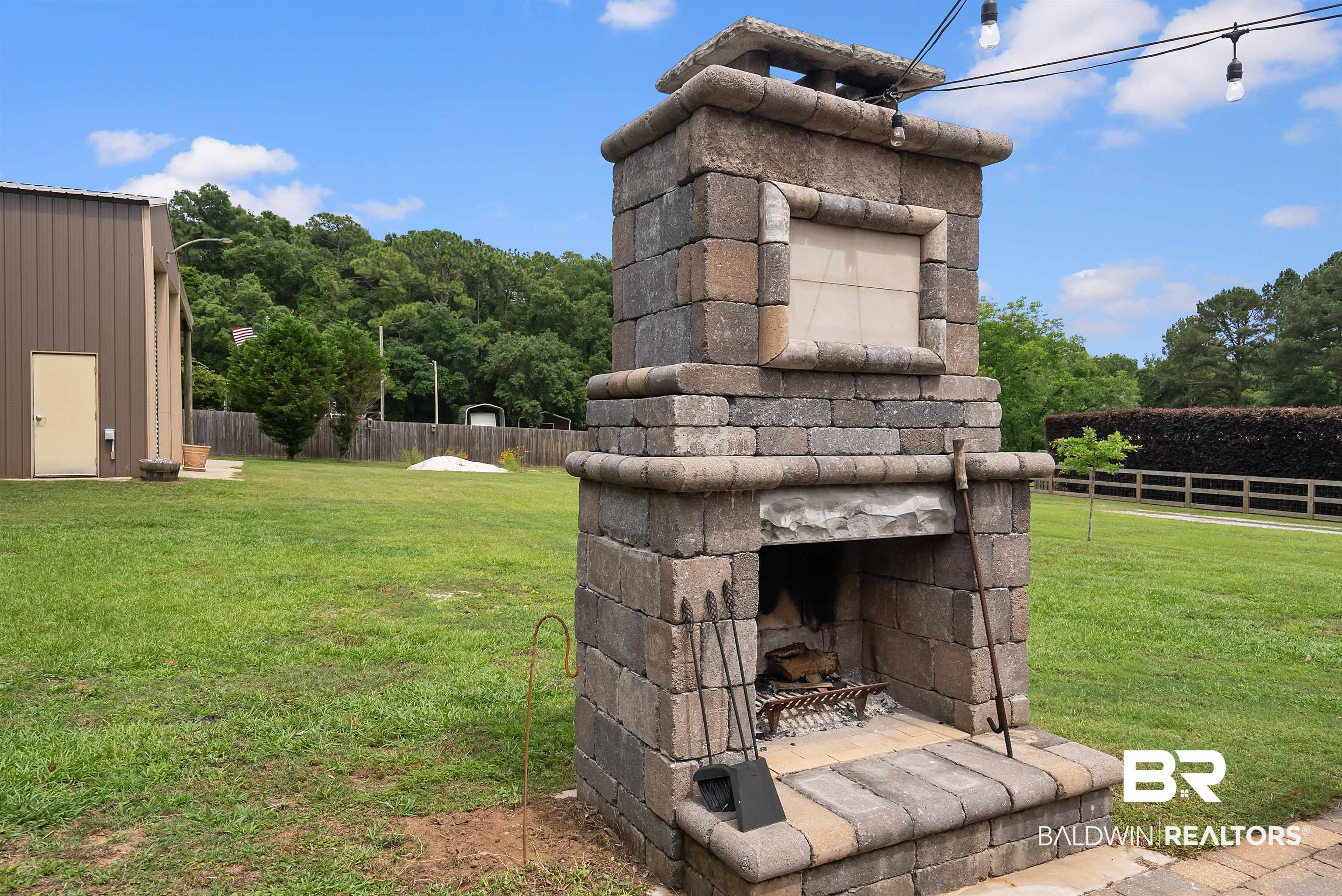 12070 Comalander Road Fairhope, AL 36532 - Photo 44 of 50 Outdoor stone fireplace featuring a hearth, wood storage, and integrated pizza oven