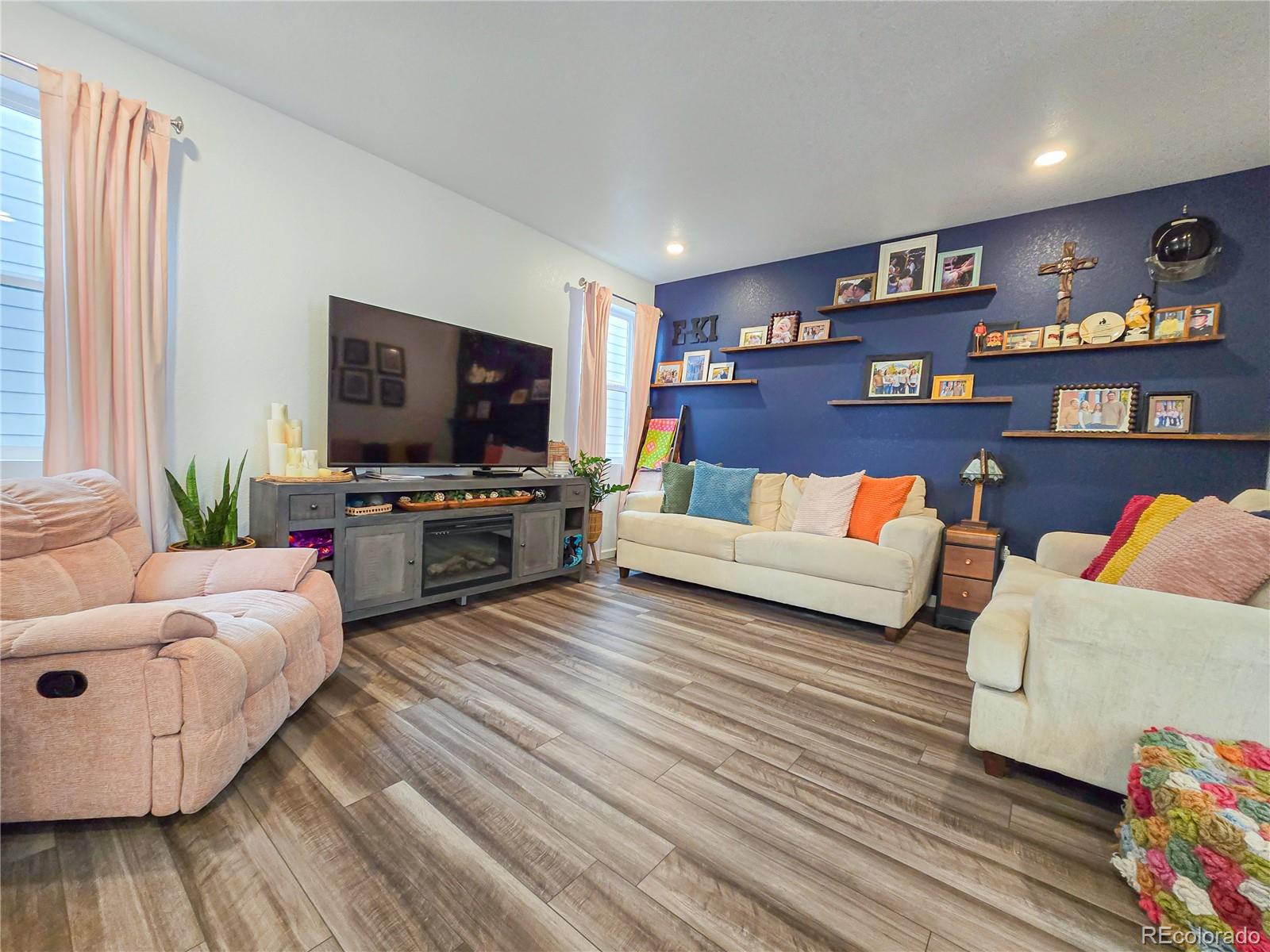 2084 Chambers Road Brighton, CO 80601 - Photo 13 of 50 a living room with furniture and a flat screen tv