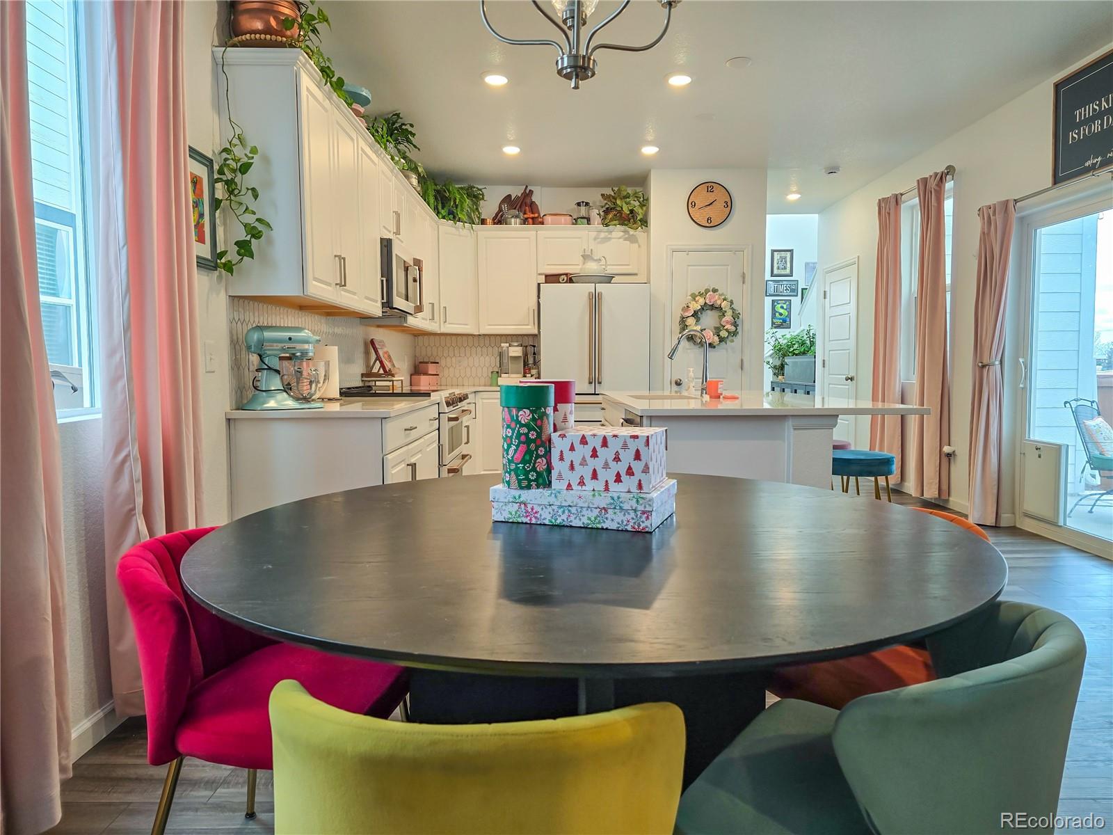 2084 Chambers Road Brighton, CO 80601 - Photo 15 of 50 a large kitchen with stainless steel appliances a dining table chairs and stove