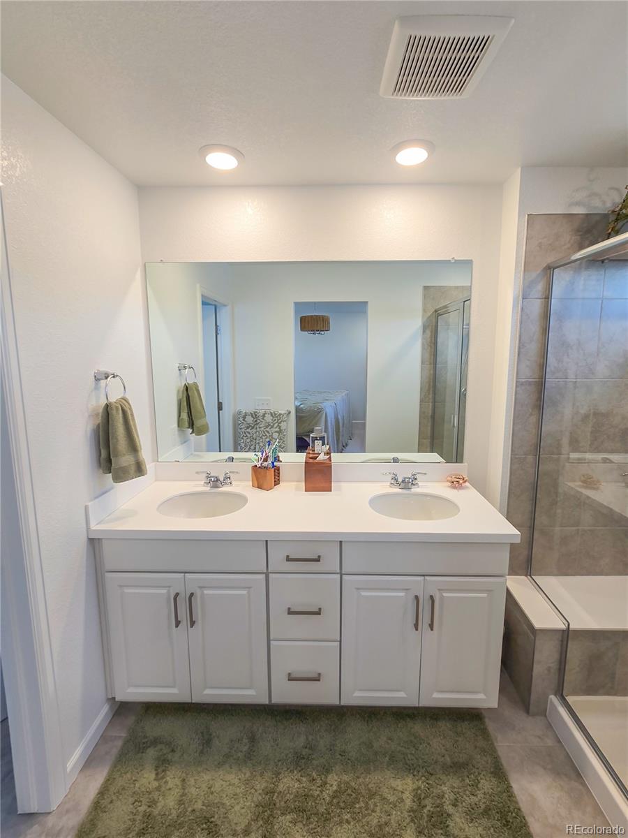 2084 Chambers Road Brighton, CO 80601 - Photo 33 of 50 a bathroom with a sink double vanity and a mirror