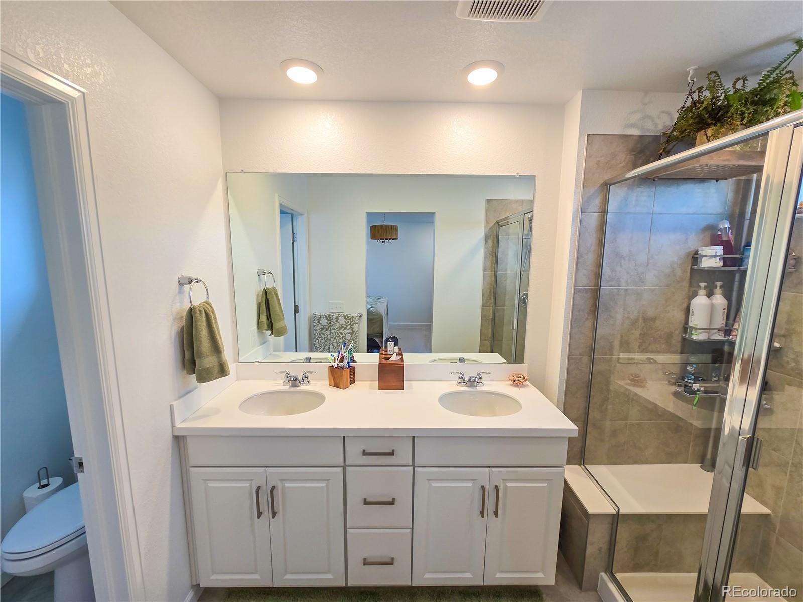 2084 Chambers Road Brighton, CO 80601 - Photo 35 of 50 a bathroom with a sink double vanity and a mirror