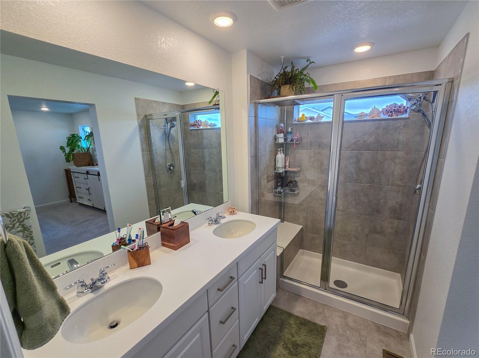 2084 Chambers Road Brighton, CO 80601 - Photo 36 of 50 a bathroom with a sink a toilet and shower