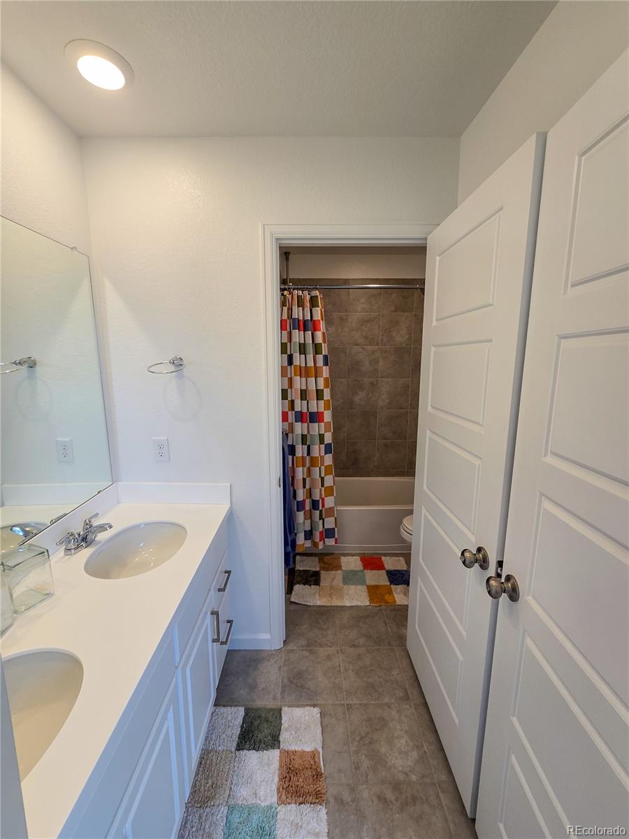 2084 Chambers Road Brighton, CO 80601 - Photo 37 of 50 a bathroom with a sink a toilet and shower