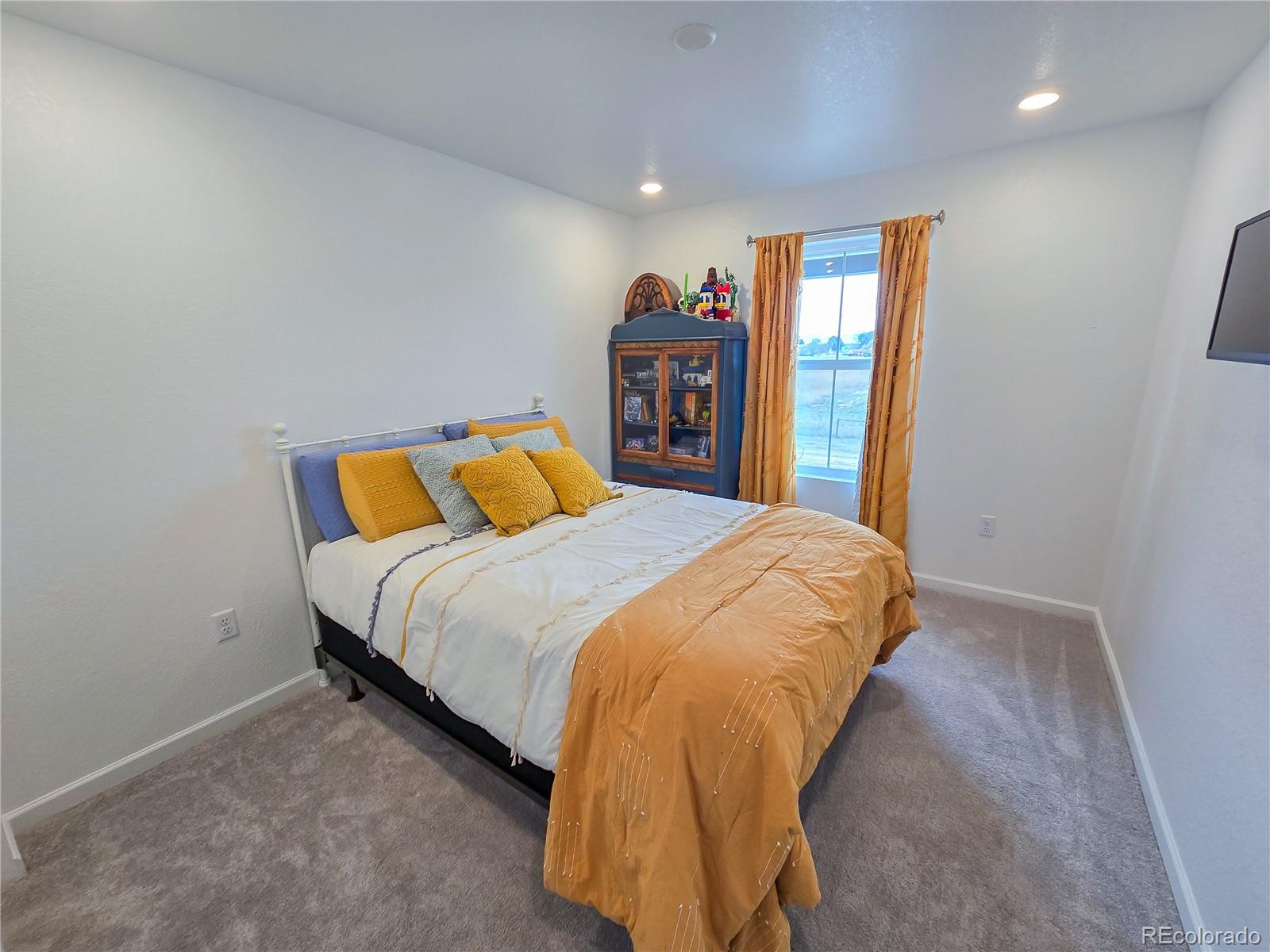 2084 Chambers Road Brighton, CO 80601 - Photo 39 of 50 a bed sitting in a bedroom next to a window