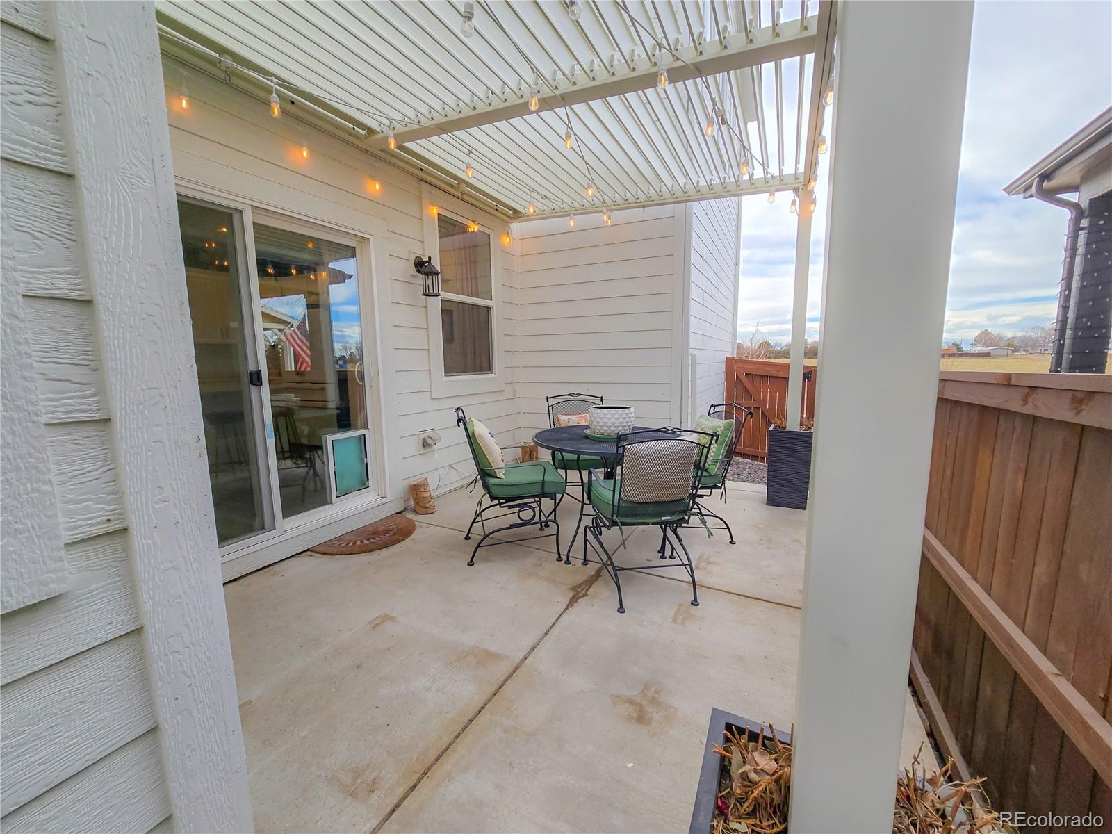 2084 Chambers Road Brighton, CO 80601 - Photo 46 of 50 a view of a patio with table and chairs and couches with wooden floor