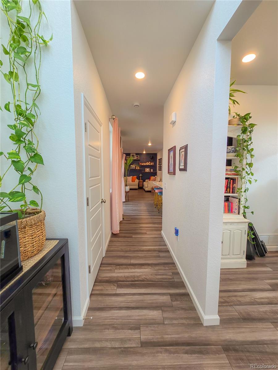 2084 Chambers Road Brighton, CO 80601 - Photo 8 of 50 a view of a hallway with wooden floor and a potted plant