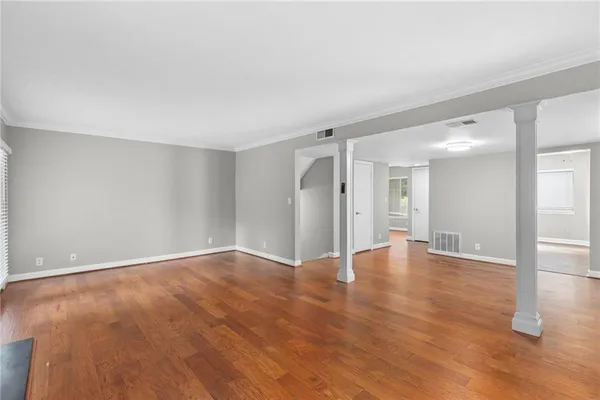 a view of an empty room with wooden floor