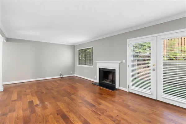 a view of empty room with wooden floor and fireplace